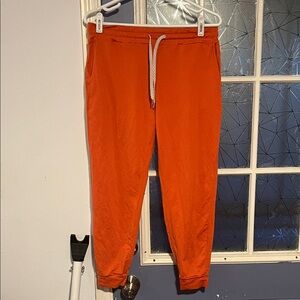 Vuori Men's Bright Orange Joggers waist is 15 and stench to 17